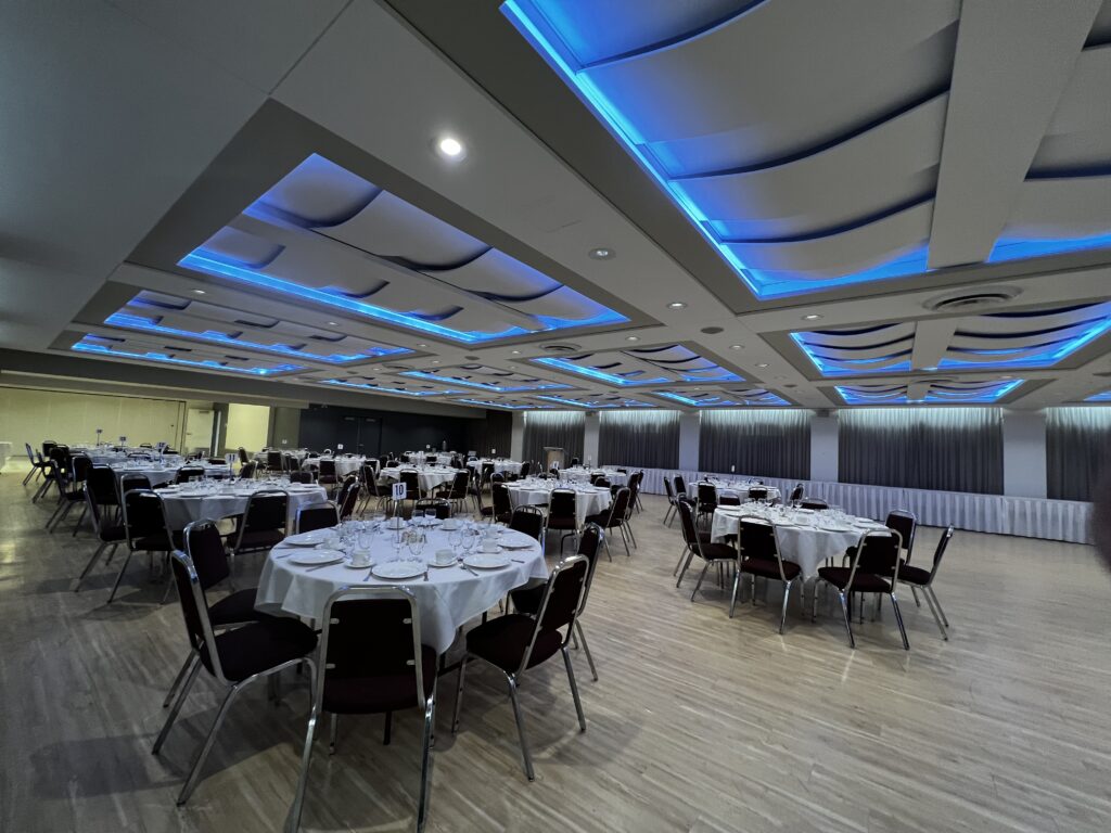 Edmonton's Polish Hall Conference Centre room set up for a banquet with blue coloured ceiling lights.