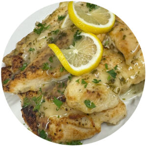 Fish with lemon sauce, fresh parsley and lemon slices, ready to serve